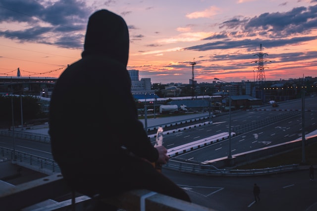 мужчина сидит на перилах над ж/д путями